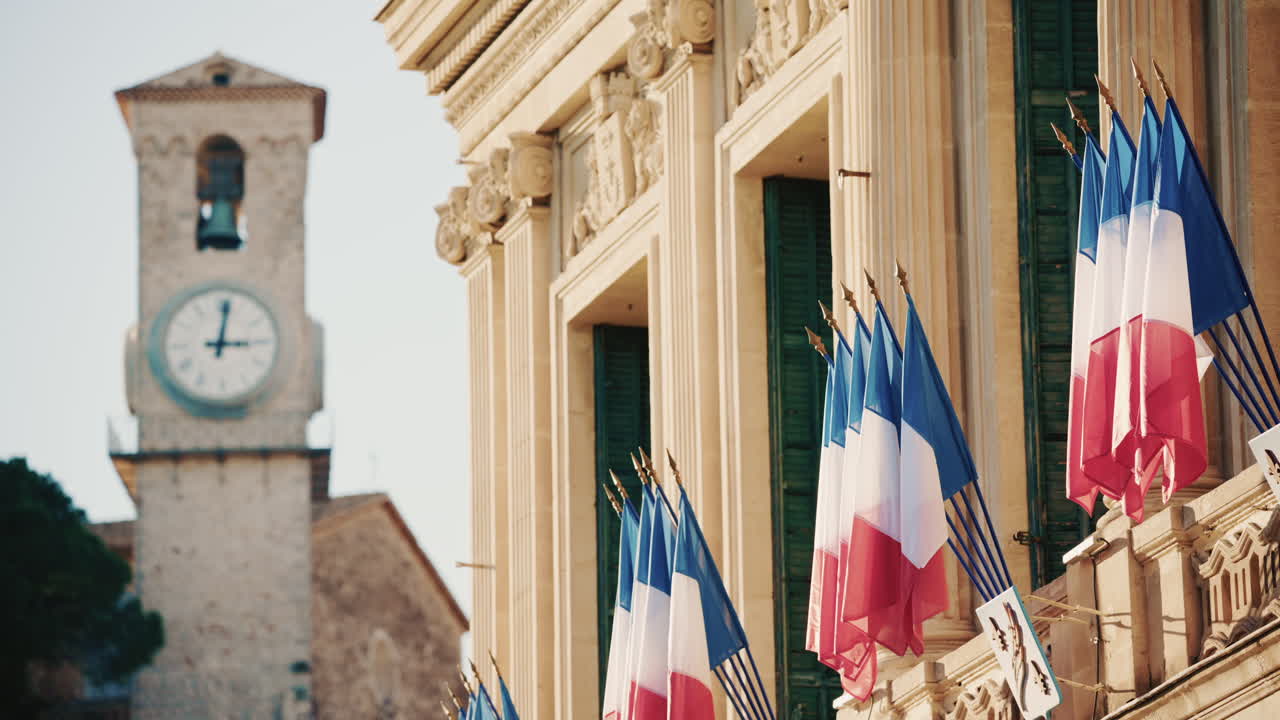 Campo lungo di un edificio storico decorato con bandiere tricolori francesi in una giornata limpida