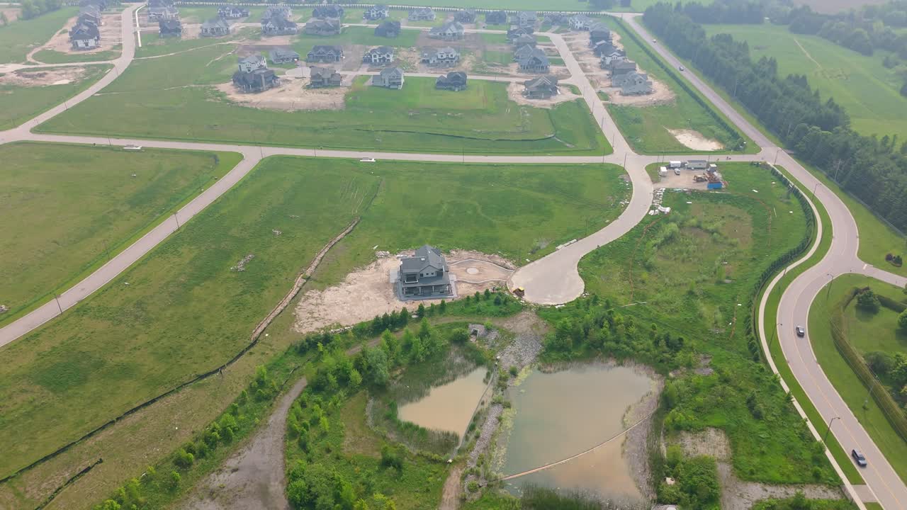 Drone aerial of new housing development build site in Caledon, Ontario, misty sunlight, addressing home shortage