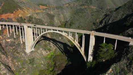 Luftaufnahme-Der-Bixby-Bridge,-Während-Autos-über-Die-Bogenbrücke-Entlang-Des-Highway-1-Fahren-Big-Sur,-Kalifornien