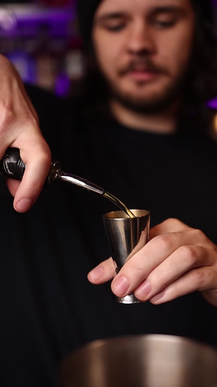 Barman che versa una bevanda in un jigger