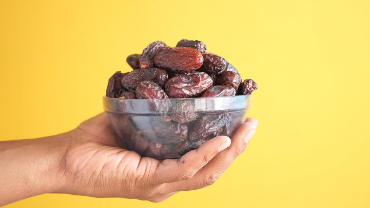 Hand pick fresh date fruit in a bowl on table