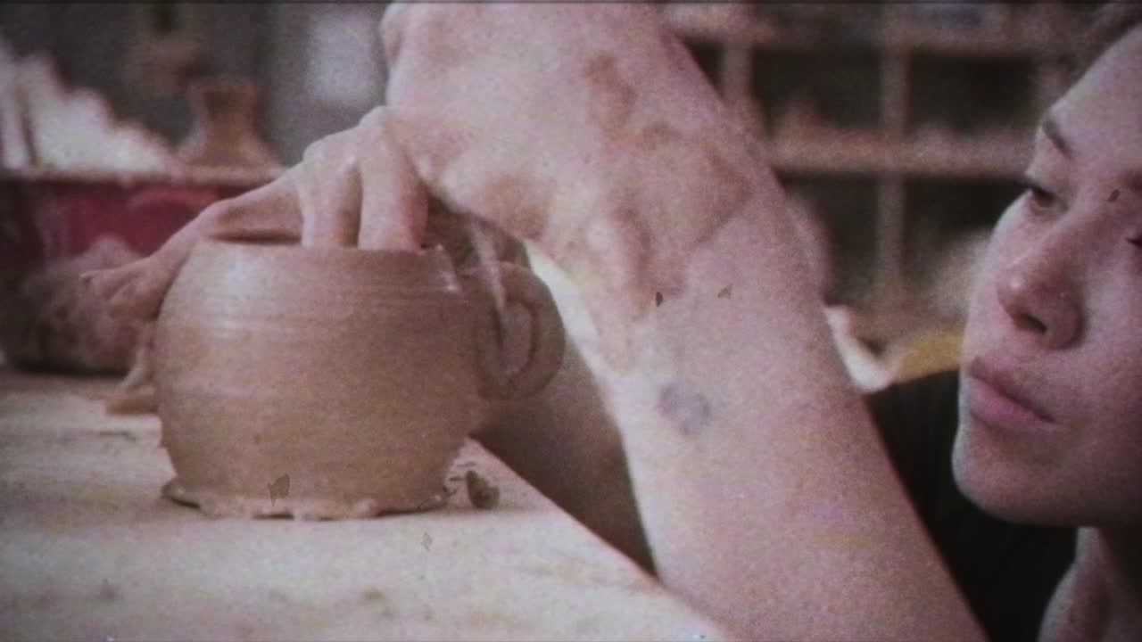 Giovane donna crea una brocca d'argilla. Mani femminili modellano la ceramica. Effetto vintage