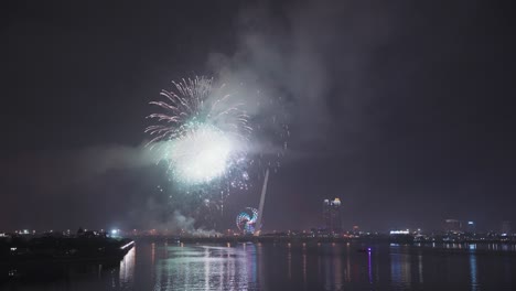 colorful fireworks light up sky for lunar new year and tet holiday over reflecting in the han river of danang, vietnam