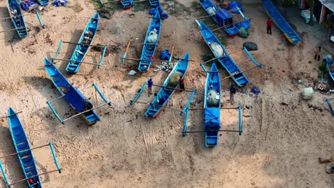 fishermen and their outrigger canoes on a sandy beach
