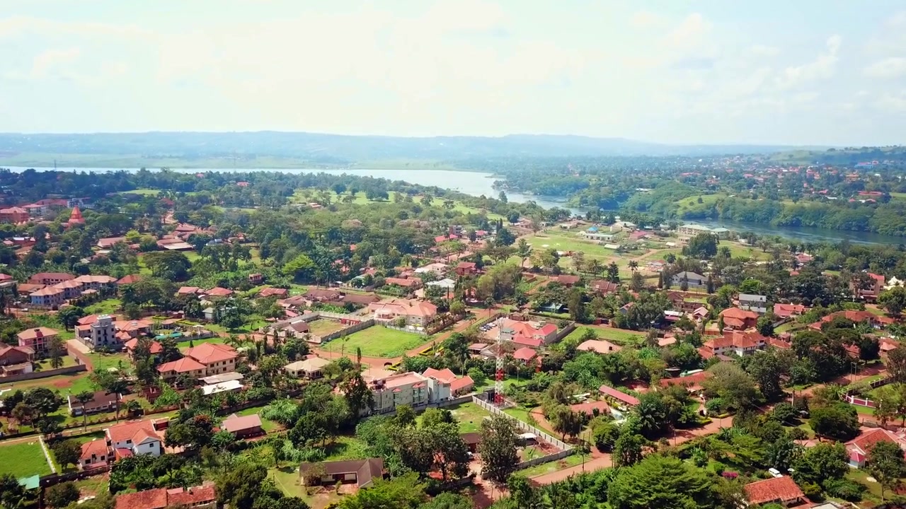 Volando sopra lo skyline di Jinja con il fiume Nilo sullo sfondo in Uganda, Africa orientale. Ripresa aerea con drone.