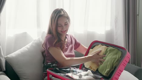 linda mujer felizmente comprimiendo una maleta sonriendo con su pasaporte y tarjeta de crédito