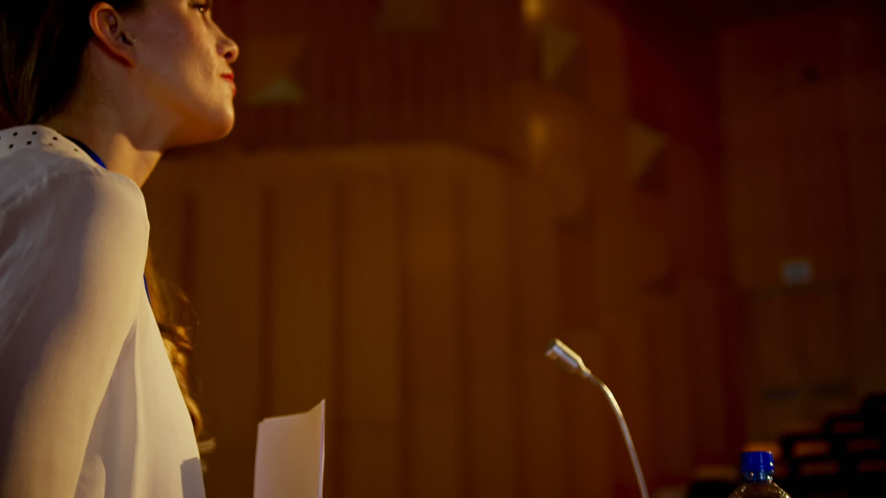 빈 강당에서 연설을 연습하는 젊은 백인 사업가 4k