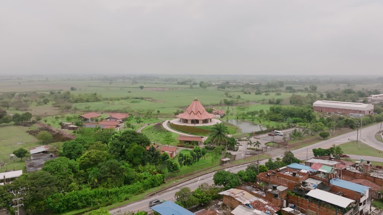 Aerial footage rising up showing a road and the Baha’i House of Worship in Cali, Colombia