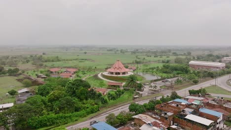 aerial footage rising up showing a road and the baha’i house of worship in cali, colombia