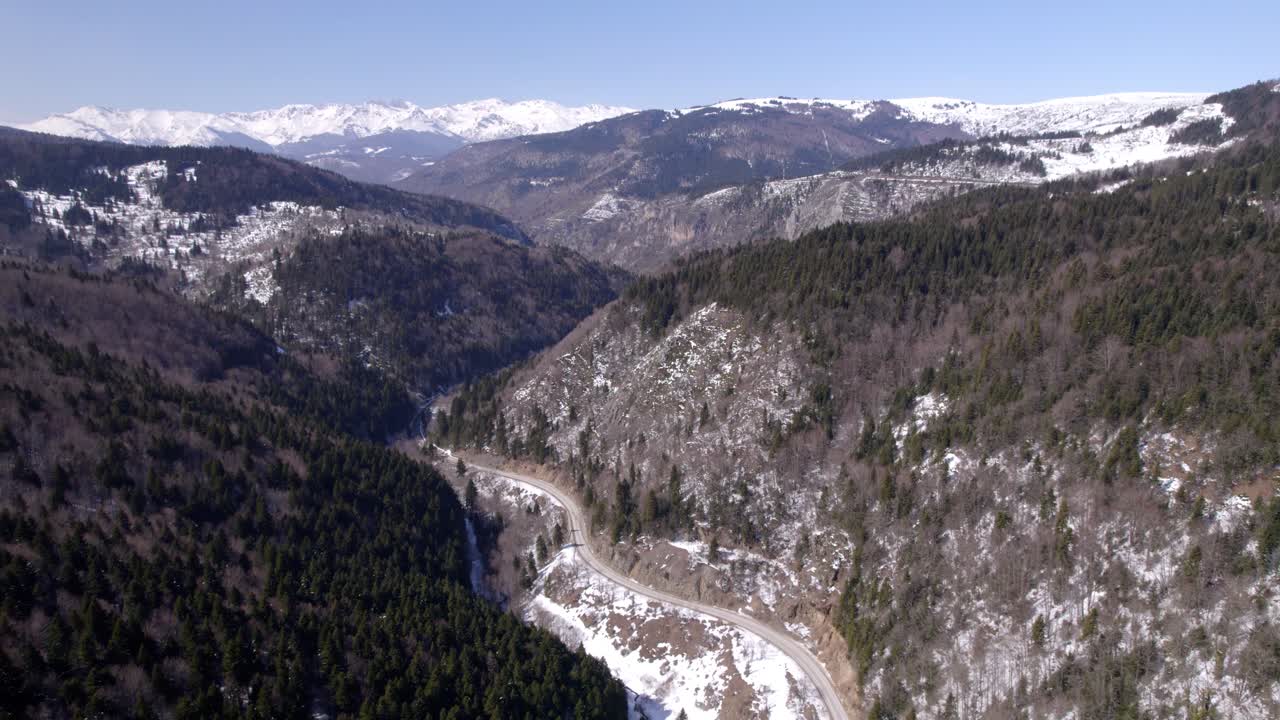 video de avión no tripulado de las montañas de invierno macedonias y un camino sinuoso