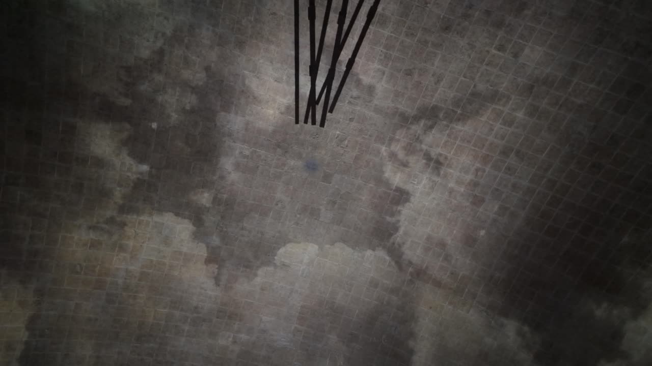 Abstract Immersive dome projection casting long geometric shadows across a circular stone-like surface, creating dynamic radial motion and a cinematic visual atmosphere at Rajadamnern Stadium