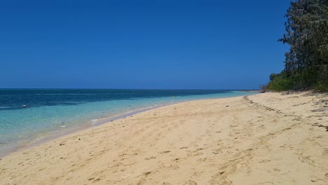 Langsamer-Lufttiefflug-über-Sandstrand-Auf-Grüner-Insel