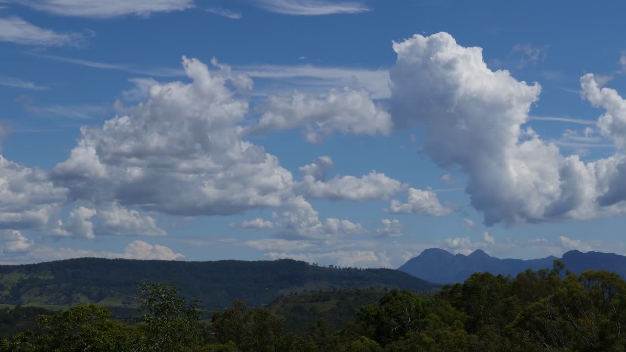 산악 지형 위의 하늘을 가로질러 움직이는 구름