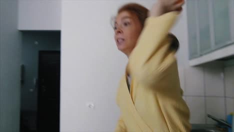 mujer en una bata de baño moviéndose en un apartamento
