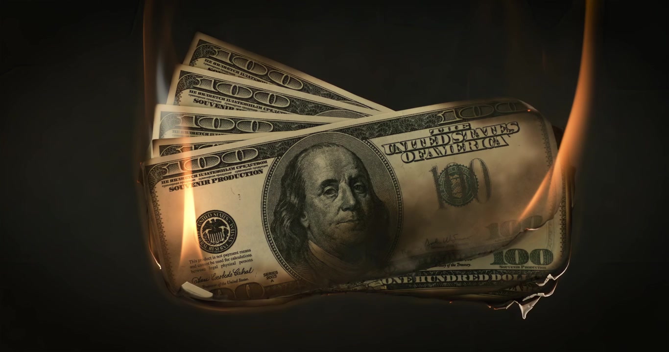 Banconota da un dollaro in fiamme su sfondo scuro