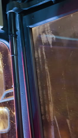 vista cercana del interior de un automóvil en movimiento, con reflejo de luz visto a través de la ventana con efecto de borrón de movimiento