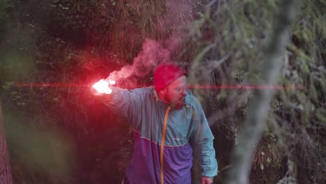 man with red flare in forest