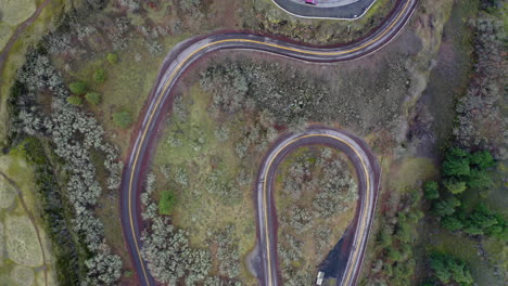 aerial view of a winding hairpin road through a natural landscape