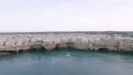 Aerial-flyover-the-sea-towards-the-town-of-Polignano-a-Mare-,-Italy