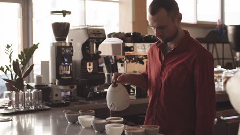 male caucasian barista brewing coffee in cafe