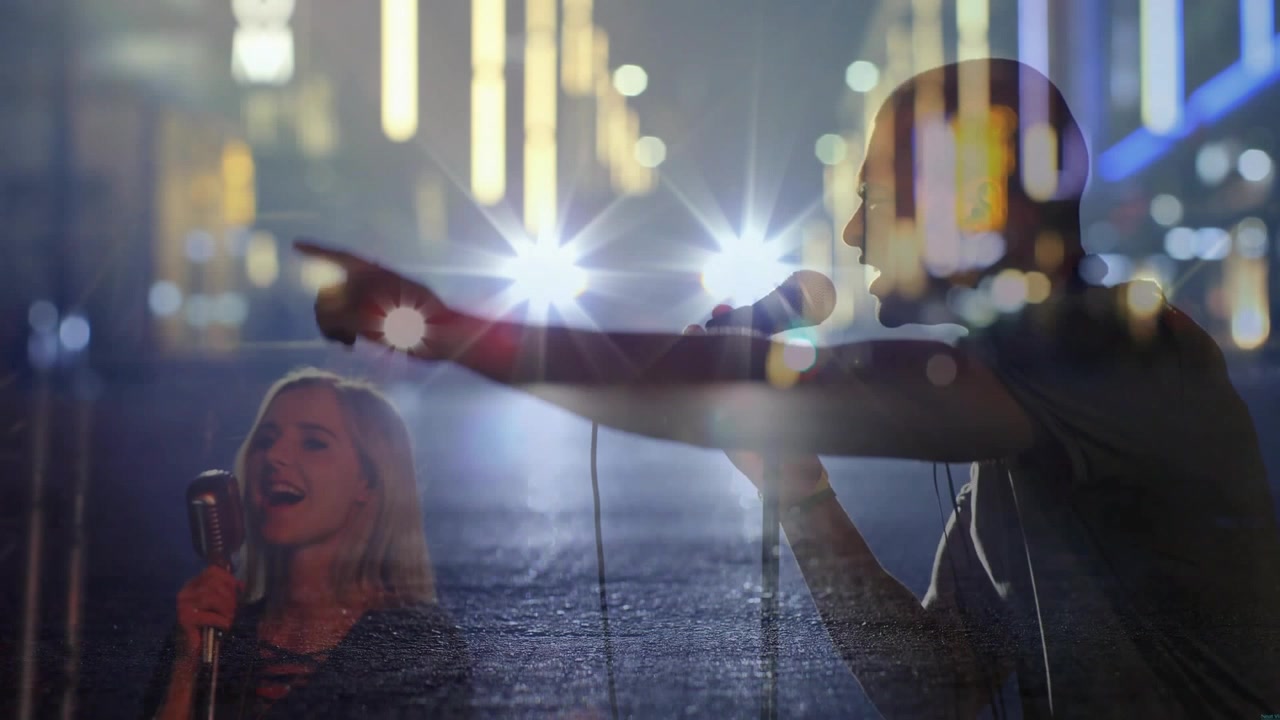 Male singer leaning into mic, cam pulling back revealing music duo singing with starburst asphalt