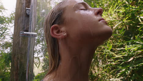 young woman in shower wearing bikini washing body with refreshing water enjoying natural beauty spa showering outdoors in nature 4k