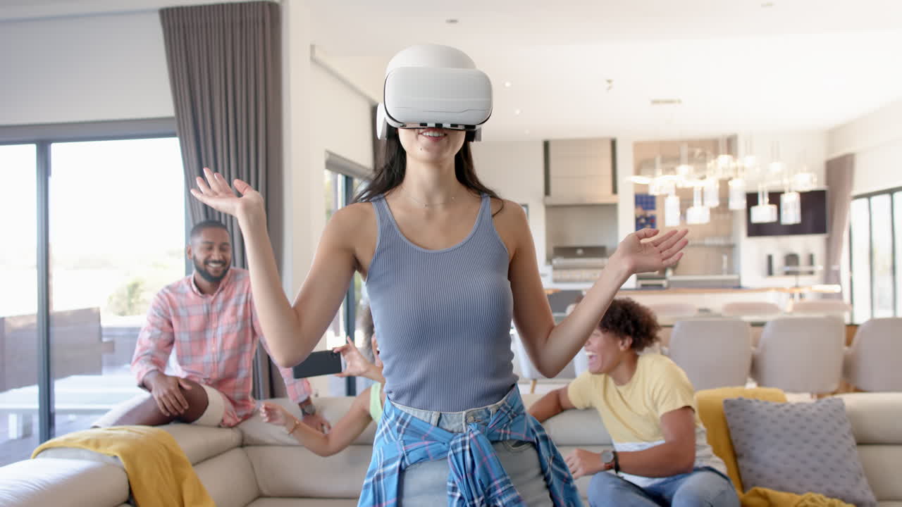 Using VR headset, woman enjoying virtual reality game with Diverse friends at home