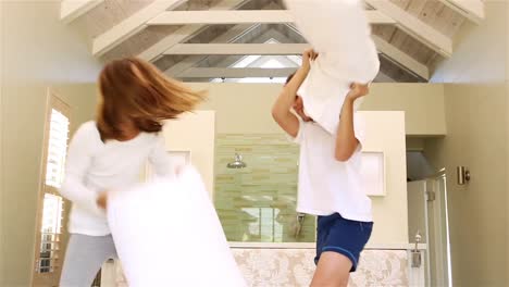 siblings having pillow fight together