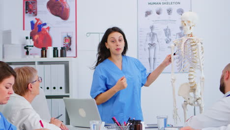 médico describiendo el diseño de la columna vertebral humana delante de sus colegas