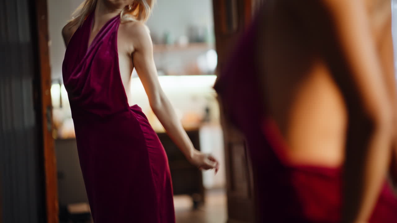 Dancing girl looking mirror in stylish silk dress. Sexy woman planning outfit