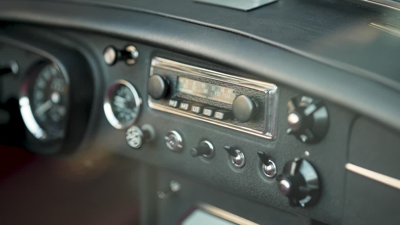 Nahaufnahme des Armaturenbretts eines Oldtimers mit Radioanzeigen und Schaltern MG-Wagen