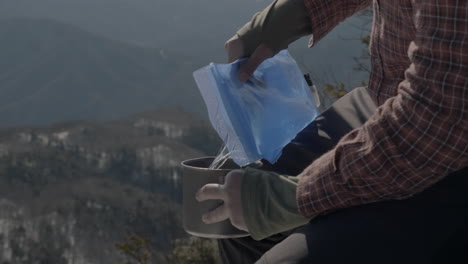 a man boiling water in a winter mountain