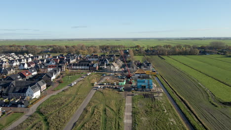 Ausleger-Einer-Baustelle-In-Einem-Neu-Gebauten-Vorortquartier,-Umgeben-Von-Grünen-Wiesen