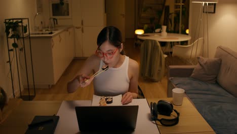 woman eating sushi while having a video call