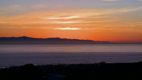 the sun sets behind the channel islands in southern california