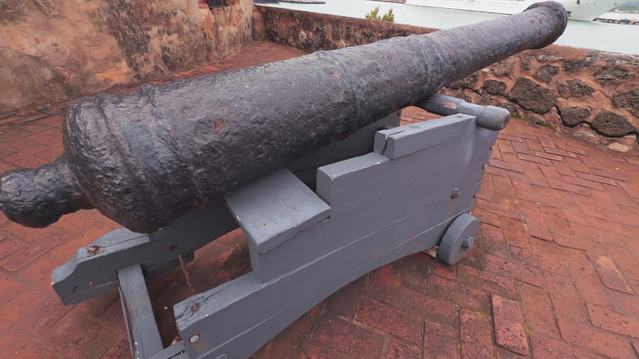 Two antique cannons and a historic sentry box on the ramparts of Fortaleza San Felipe, overlooking the ocean in Puerto Plata, Dominican Republic