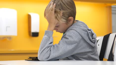 niño de escuela primaria cansado leyendo en una tableta, tiro medio estático