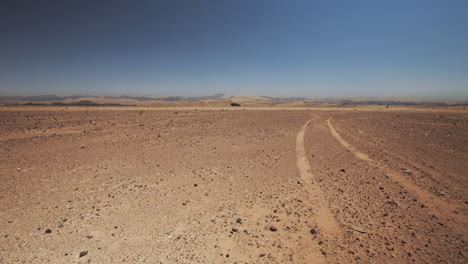 Black car cross the vast Wadi Araba desert from left to right in Jordan. The Arabah valley, Arava, Aravah, south of the Dead Sea. 4K footage