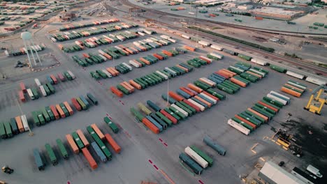 beautiful aerial of yard jockey truck driving with container in a intermodal terminal rail road with yard full of containers