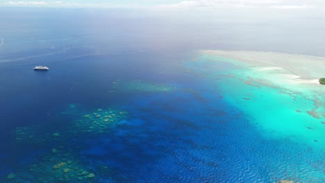 cruise ship anchored off fiji island with coral reef surrounding