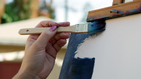 Video-En-Cámara-Lenta-De-Artista-Femenina-Aplicando-Pintura-Azul-Al-Lienzo