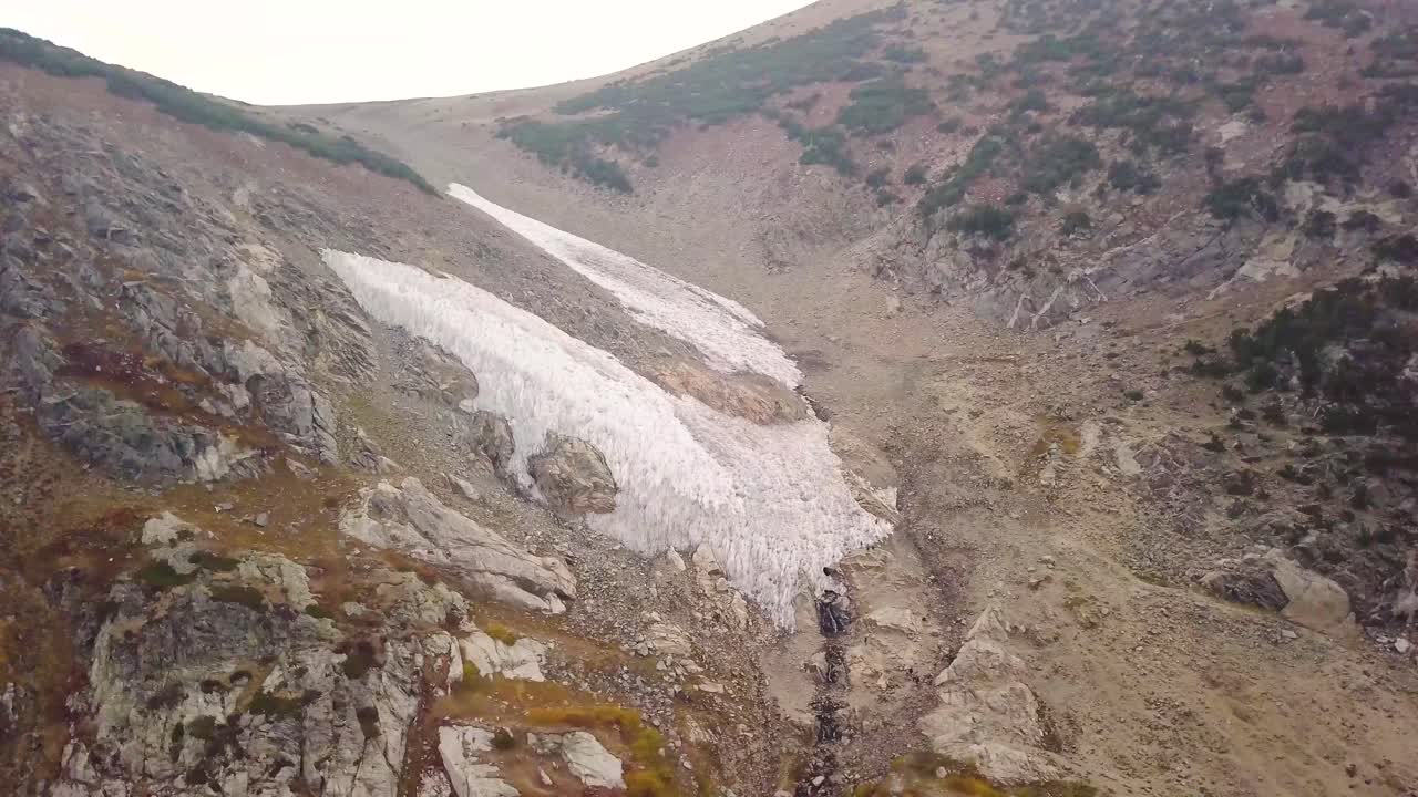 una toma panorámica de camiones de un glaciar que se derrite en un lago alpino al atardecer a gran altura