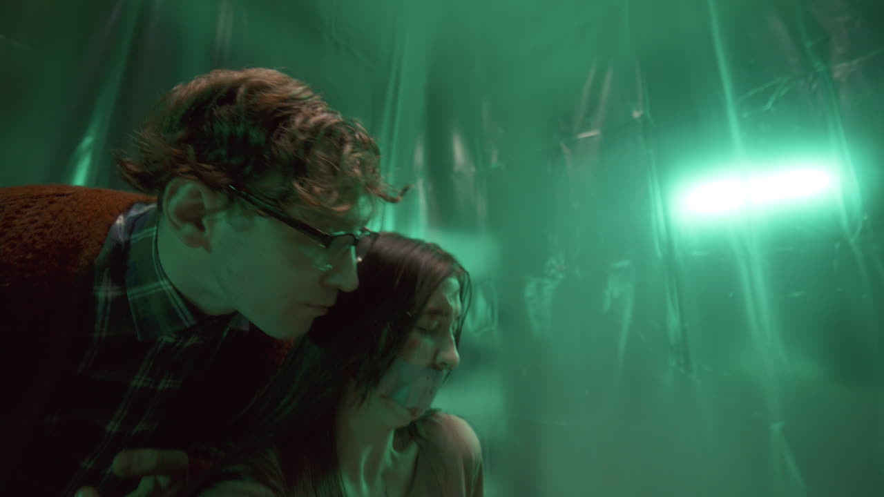 asesino psicótico amenazando a una mujer aterrorizada con la boca pegada y la cara magullada