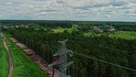 Vuelo-Aéreo-Hacia-El-Trabajador-Colgado-En-La-Torre-De-Transmisión-Y-Trabajando-En-El-Paisaje-Forestal