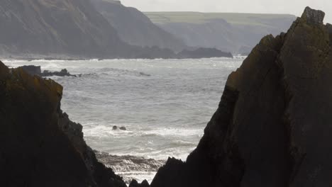 wide shot between two big rocks with sea in background at hartland quay, stoke, hartland, bideford