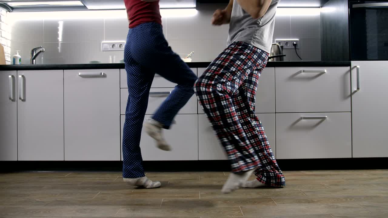 Legs of happy couple dancing in kitchen