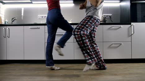 legs of happy couple dancing in kitchen