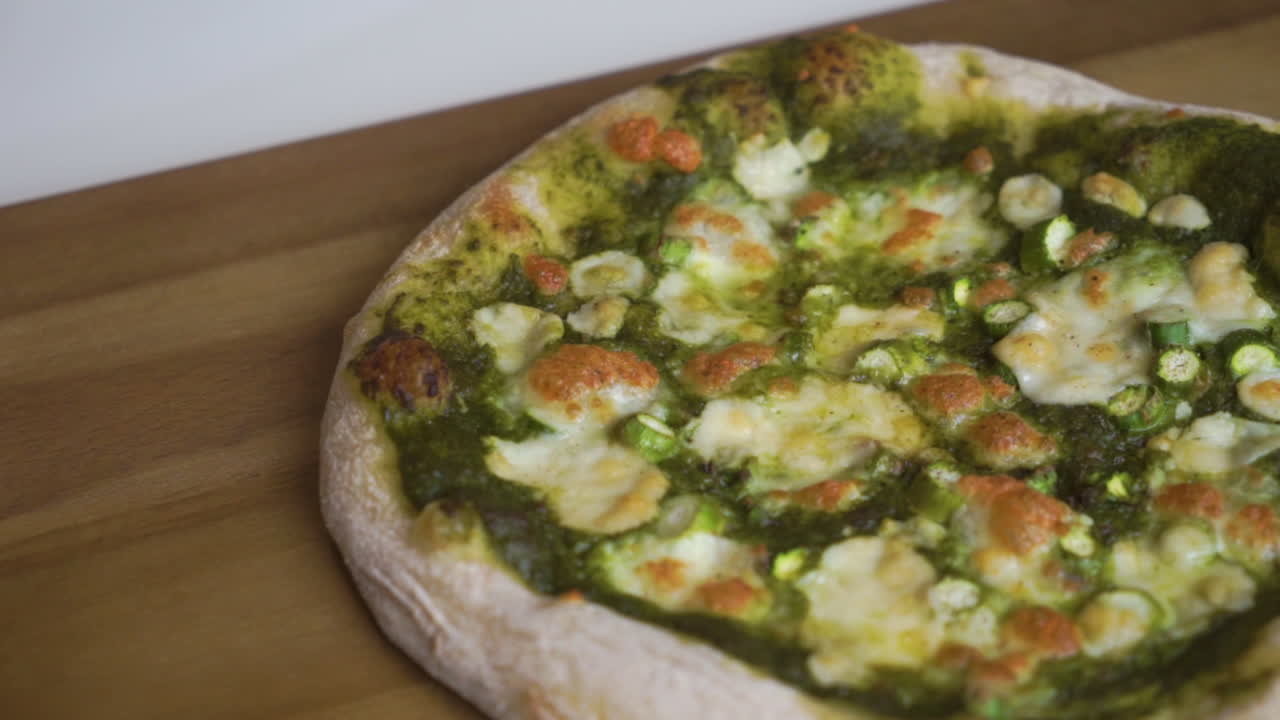 スローモーションでパンを左から右に動かし、サワードウの皮が付いたおいしい自家製イタリアンピザをスライスして家族全員で楽しむ準備ができています