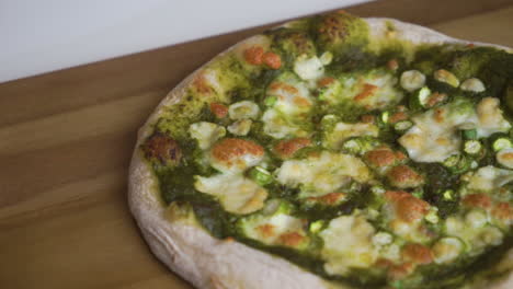 sartén a cámara lenta de izquierda a derecha de una deliciosa pizza italiana casera con una corteza de masa fermentada lista para ser cortada y disfrutada por toda la familia