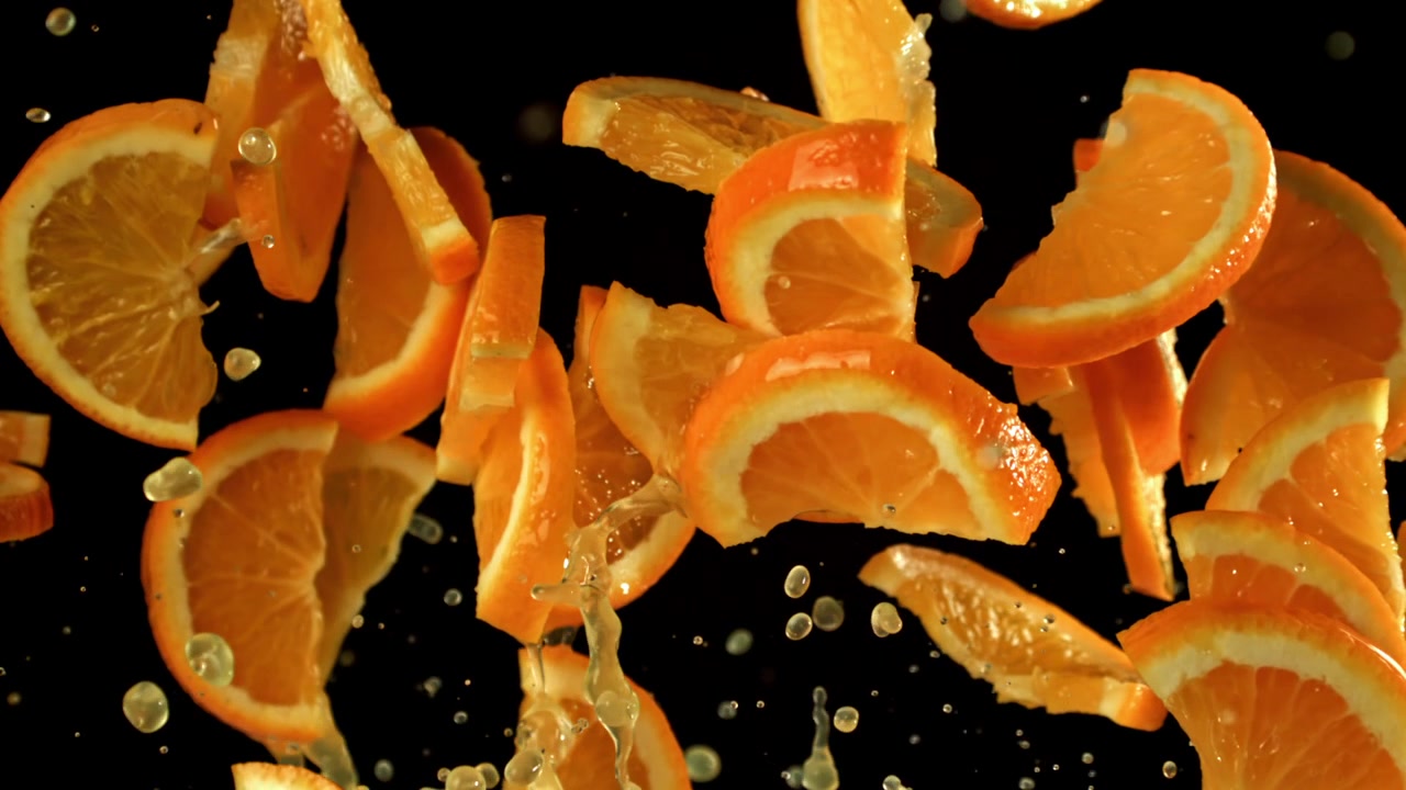 Ferske appelsinskiver og juice spruter i sakte film